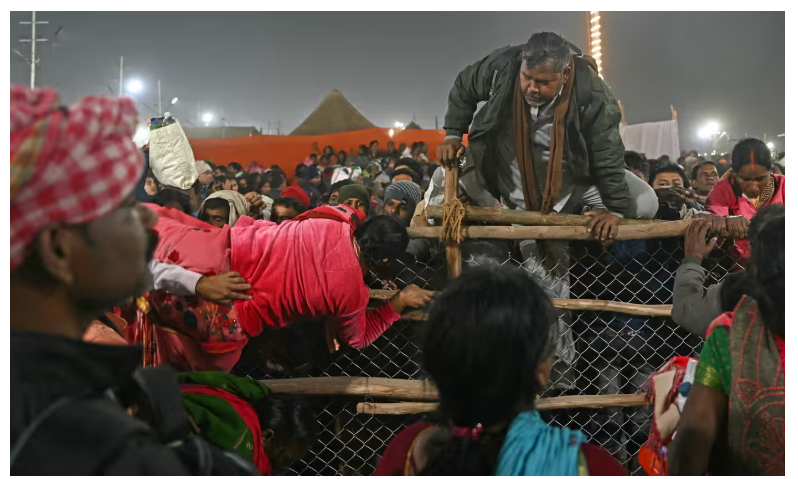 "Pilgrims attempting to jump over barricades in a frantic rush during the Kumbh Mela festival."